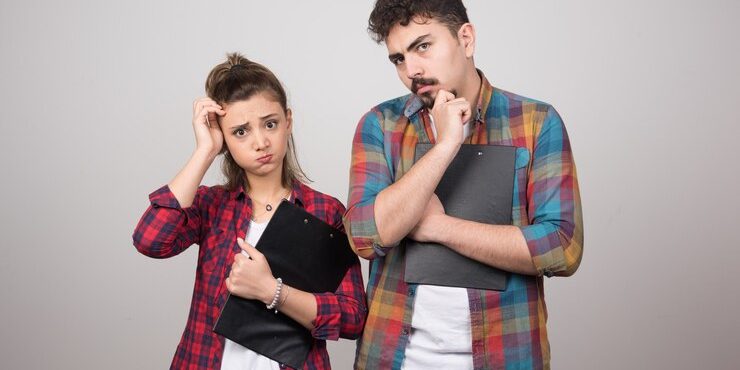 pensive-woman-holding-clipboard-near-thoughtful-man_114579-70582