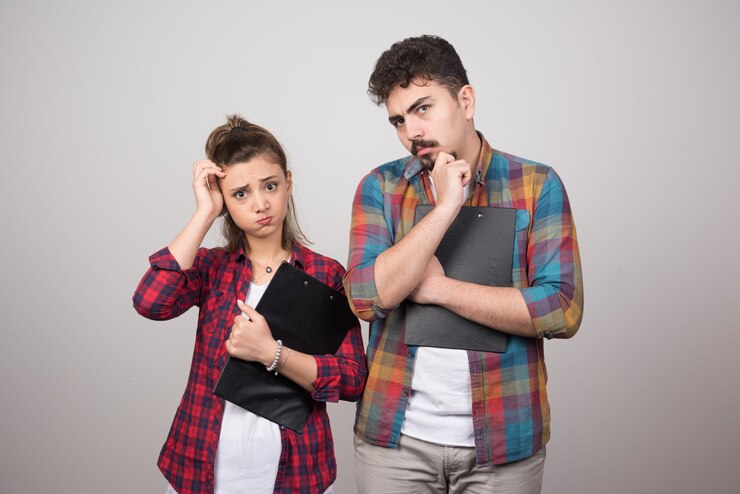 pensive-woman-holding-clipboard-near-thoughtful-man_114579-70582