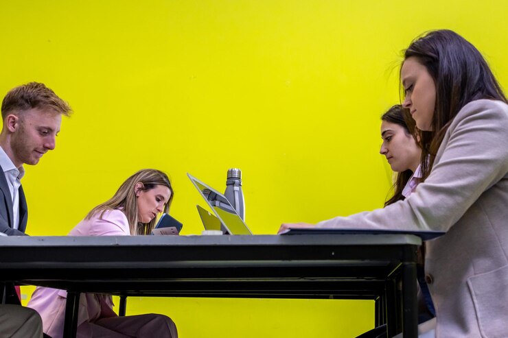 group-people-are-sitting-table-some-them-are-working-laptops_394312-7478