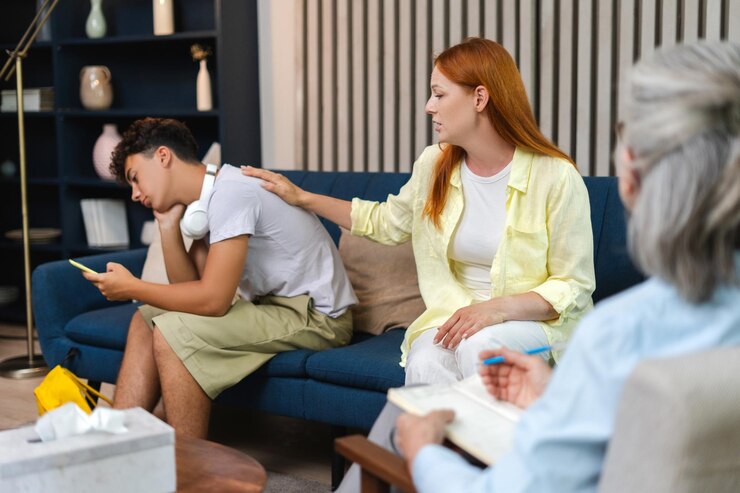 mother-comforting-sad-teenage-son-family-therapy-session-sitting-home_695242-15861