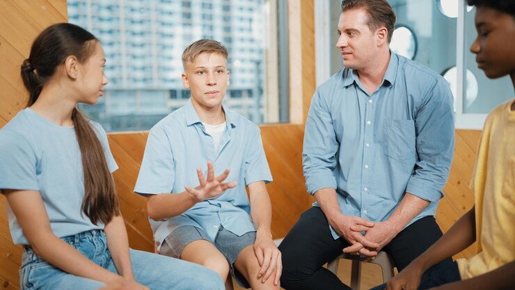 attractive-boy-sharing-experience-attend-group-therapy-edification_31965-290313